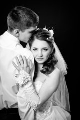 Fototapeta na wymiar Groom kissing bride on wedding. Black background.