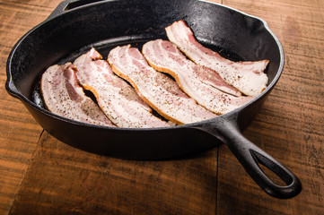 Metal frying pan with strips of bacon