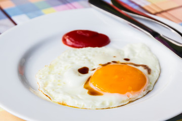  Fried egg on white dish.
