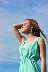 Fototapeta na wymiar Young sensual smiling blonde posing in bright sunlight outdoors