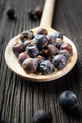 juniper berries on old wooden spoon