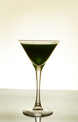 dark-green cocktail on light background