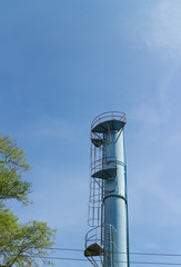 the old blue water tower with  tree and blue sky