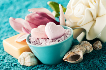 Spa setting with bath salt  and bath accessories on blue towel