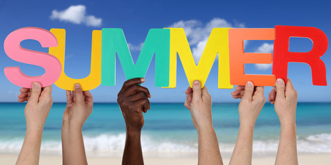 Hands holding the word summer on beach in vacation