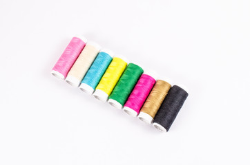 multicolor sewing threads on white background,