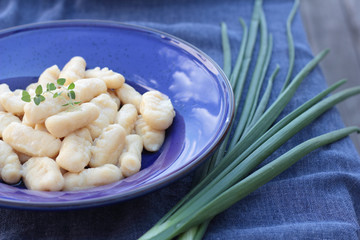 Gnocchi with oregano on a blue plate.