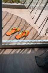 Orange flip-flops lying at a house entry