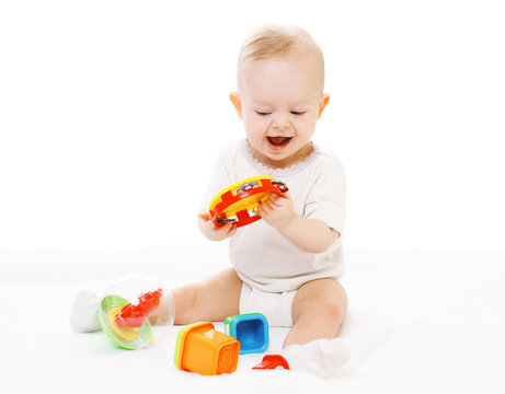 Cheerful baby in diapers playing with toys