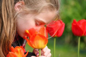     girl smelling flowers in the garden   
