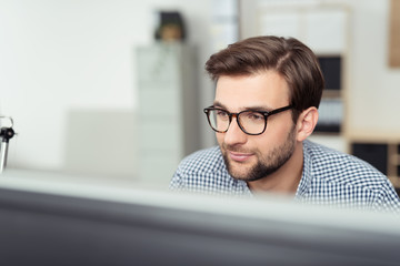 mitarbeiter im büro schaut auf pc-bildschirm