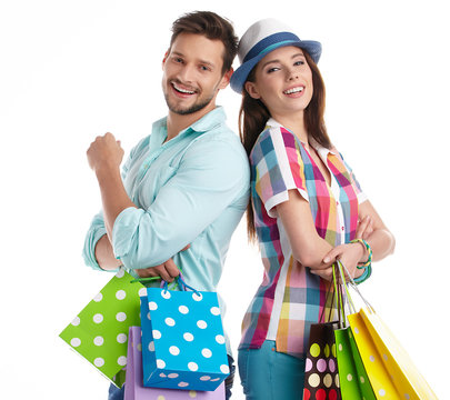 Attractive young couple holding shopping bags on white backgroun