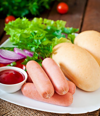 Ingredients for the preparation of hot dogs on a white plate