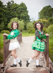 Two young beautiful girl in irish dance dress posing outdoor