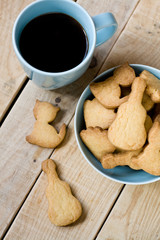 Sweet tasty cookies in the blue plate and cup of black coffee on