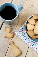 Sweet tasty cookies in the blue plate and cup of black coffee on