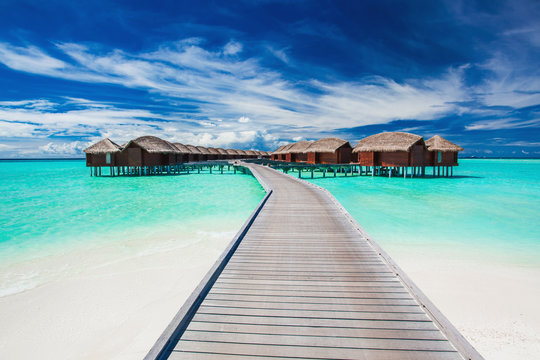 Overwater villas on the tropical lagoon connected by jetty
