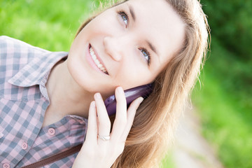 Naklejka premium Young woman using cell phone outdoors