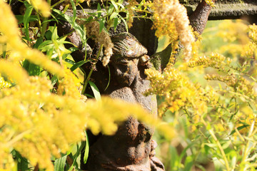 Jesus with yellow Flowers on the old village Cemetery