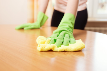 Woman cleaning stains off the table, close up photo