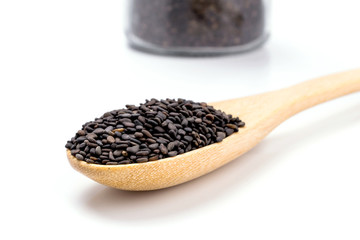 Heap of black sesame on wooden spoon