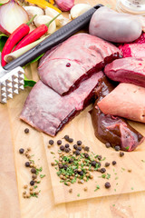 Raw fresh meat and entrails on board with condiments, Galangal,
