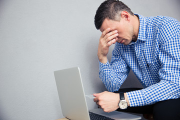 Depressed man holding credit card