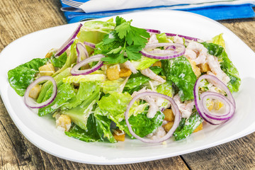 Caesar salad with shrimp on a white plate