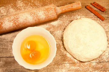 homemade baking. Fresh dough for pastry, stick cinnamon, spilled flour, broken eggs on a chopping Board