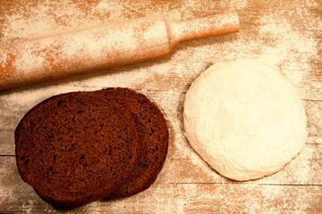 homemade baking. Fresh dough for pastry, piece of bread, spilled flour, kitchen rolling pin on a chopping Board