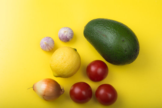 Aerial view guacamole dip ingredients on yellow cutting board