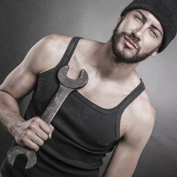 Handsome Man Standing And Holding A Wrench