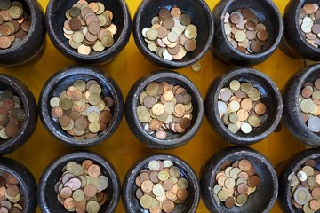 Thai coin in Buddhist monk's alms bowl