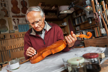 Elderly person building a violin