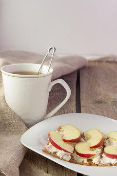 Crisp bread with cream cheese and apples and cup of tea