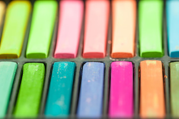 Close up Colorful chalks in a variety of colors arranged in tray