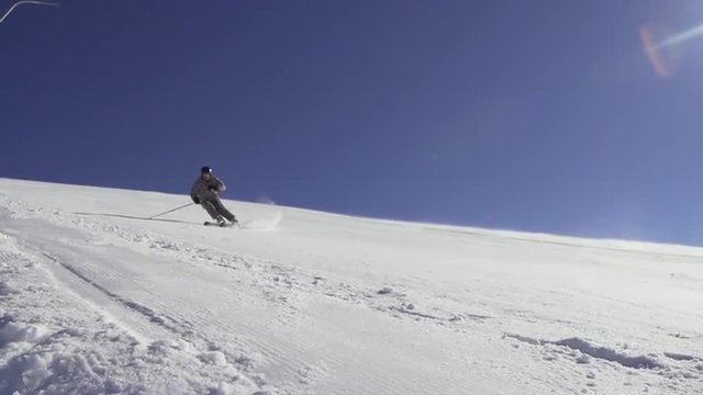 Slow Motion Rear View Of A Professional Skier Skiing Down The Ski Slope