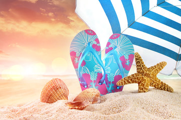 Pair of flip- flops in the sand with starfish