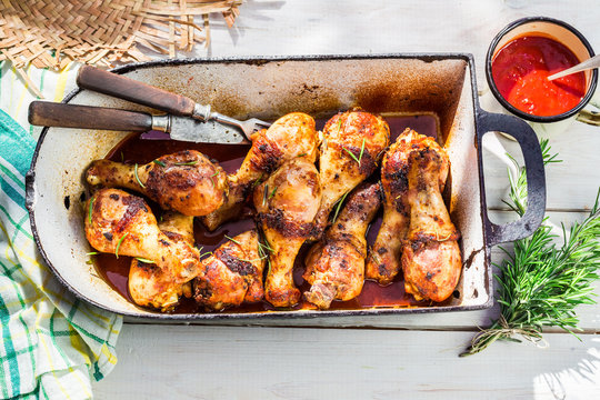 Hot chicken legs with barbecue sauce in summer kitchen