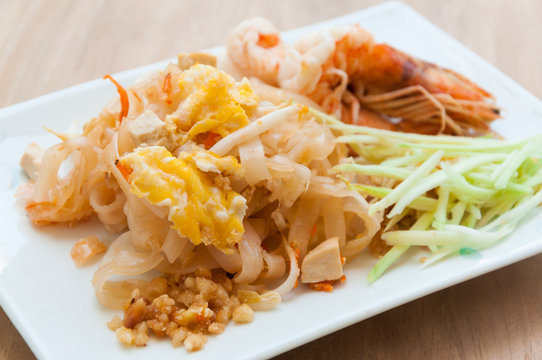 Seafood pad Thai dish of stir fried rice noodles on a square white dish