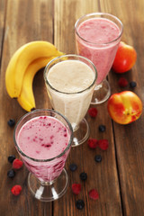 Milk cocktail with banana, blackcurrant and raspberry in a glass