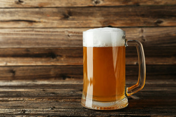 Mug of beer on a brown wooden background