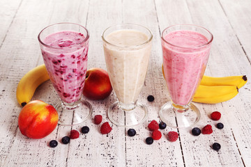 Milk cocktail with banana, blackcurrant and raspberry in a glass