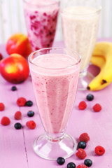 Milk cocktail with banana, blackcurrant and raspberry in a glass