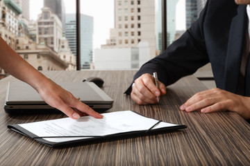 female hand pointing to businessman at signature place on a cont