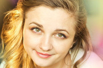 Fototapeta premium Smiling girl in the rays of the bright sun.
