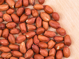 Close up of peanuts on wooden board.