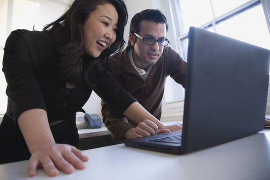 Multi-ethnic businesspeople looking at laptop