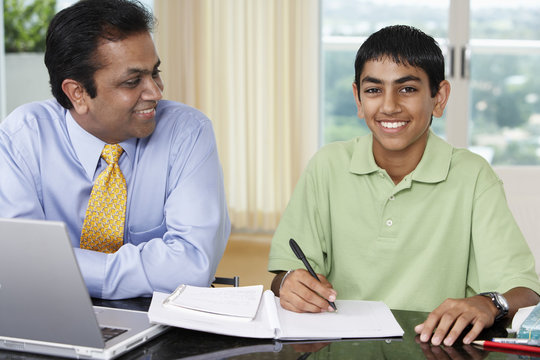 Middle Eastern father helping son with homework
