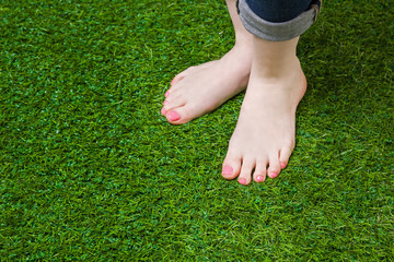Woman legs injeans standing  on green grass